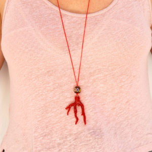 CLose up, wearing Mina's handmade pendant with synthetic coral