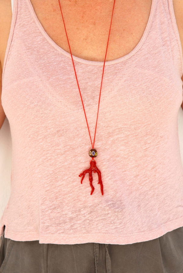 CLose up, wearing Mina's handmade pendant with synthetic coral