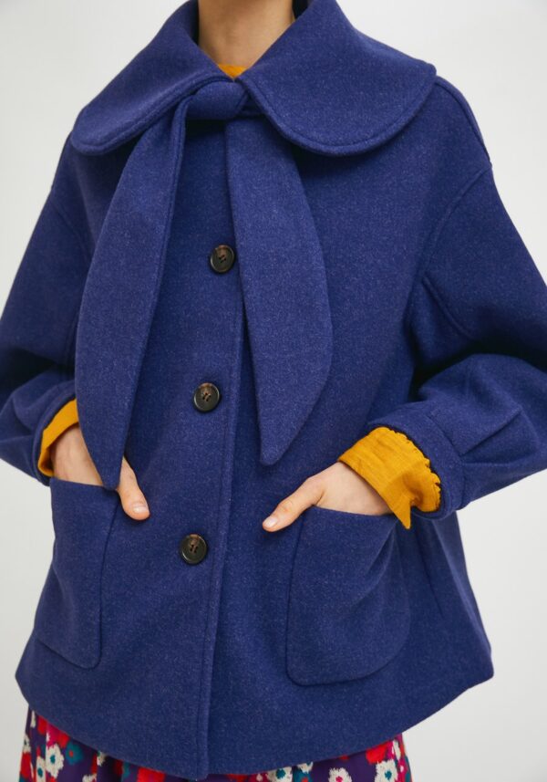 Close up photo, model wearing blue coat