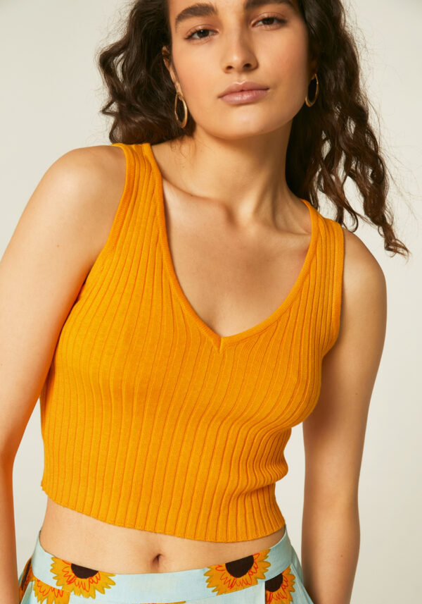 Model wears yellow strech ribbed top