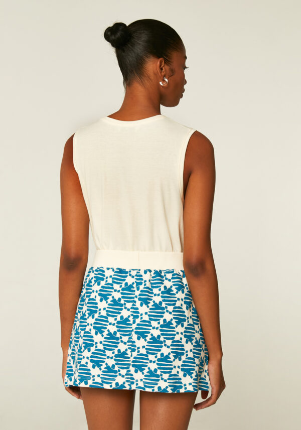Back photo, model is wearing flared mini skirt with turtle print