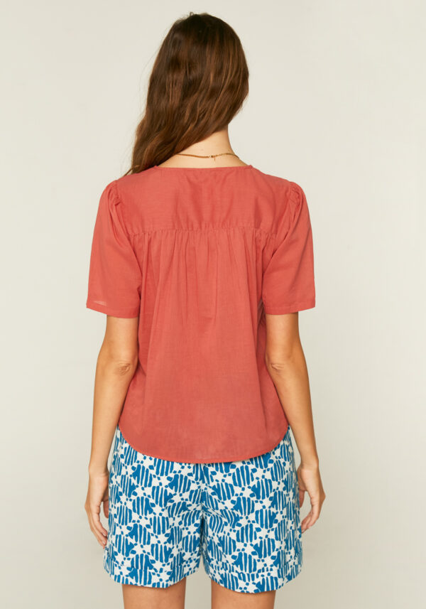 Back photo, model is wearing brown pink short sleeve blouse