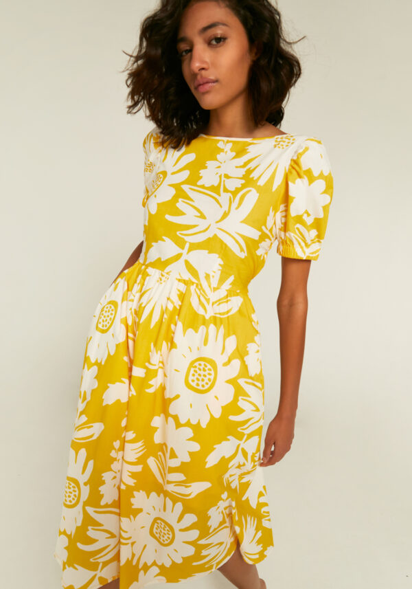 Close up photo, model is wearing yellow floral dress with puff sleeves