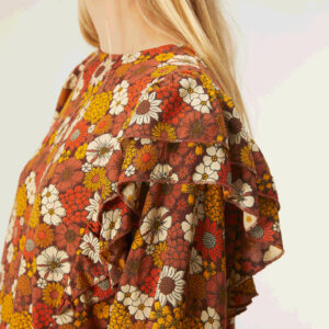 Profile photo, model wears floral print top with ruffles