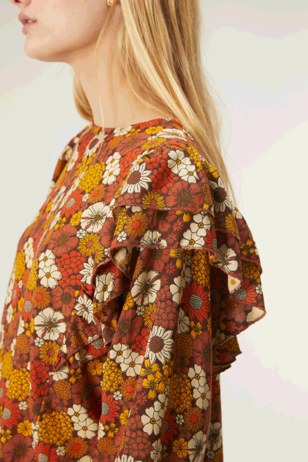 Profile photo, model wears floral print top with ruffles