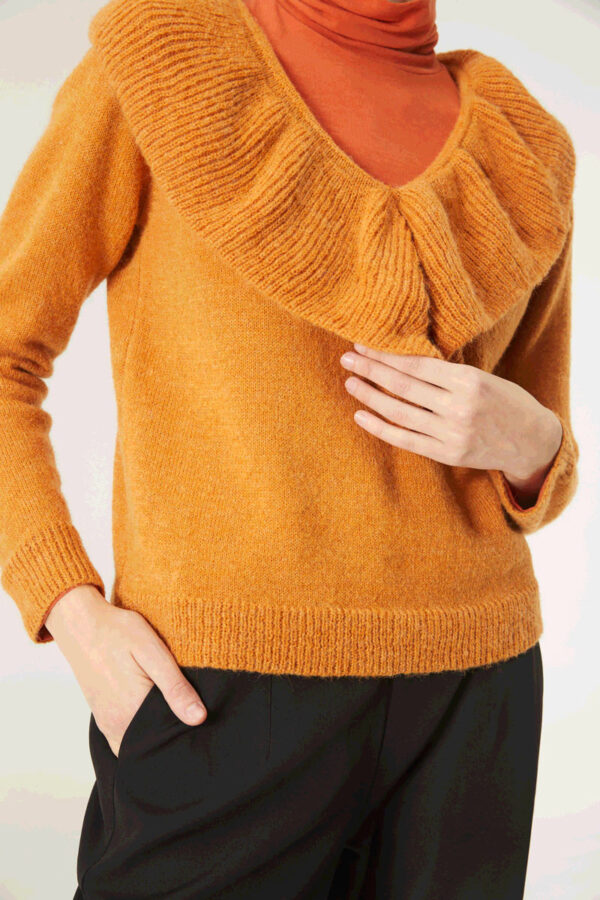 Close up photo, model wears mustard sweater
