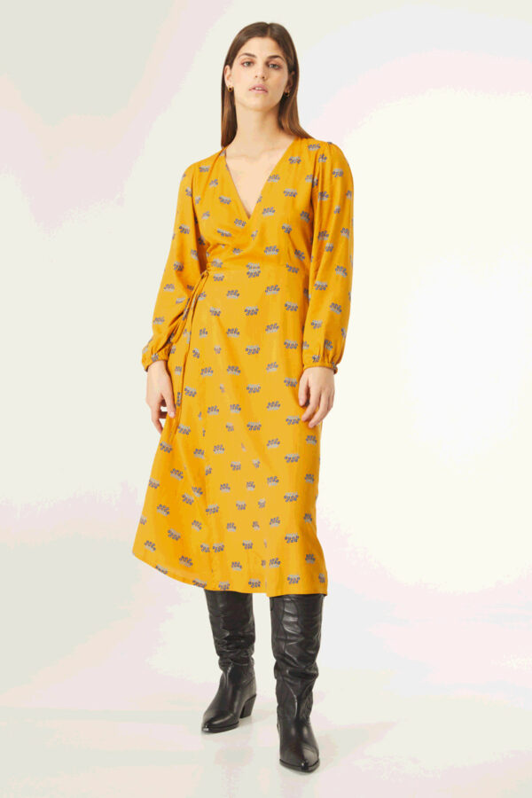 Model wears mustard print dress