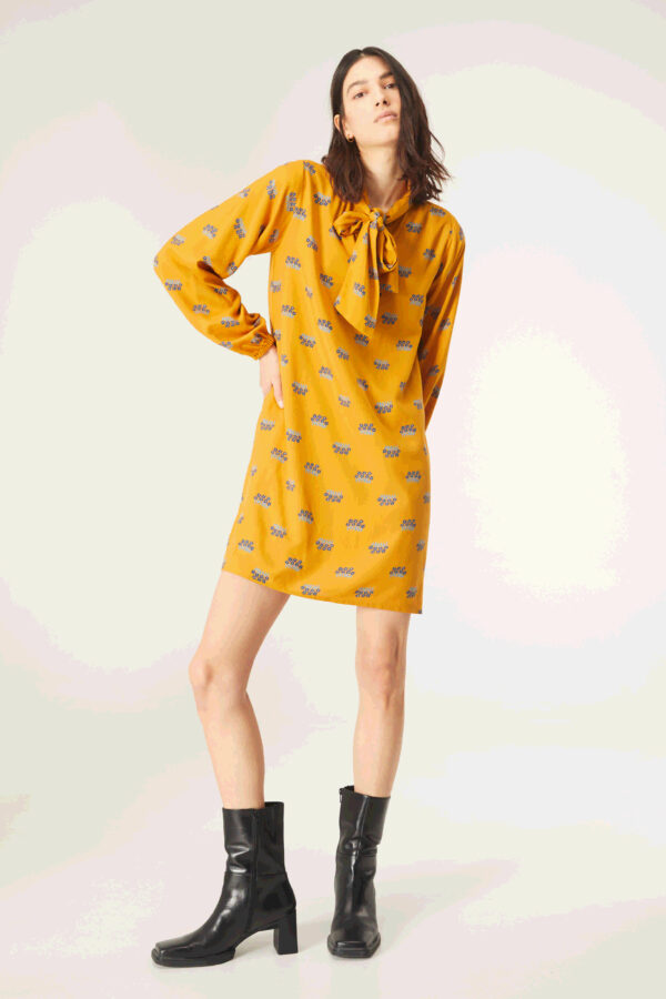 Model wears mustard floral print dress