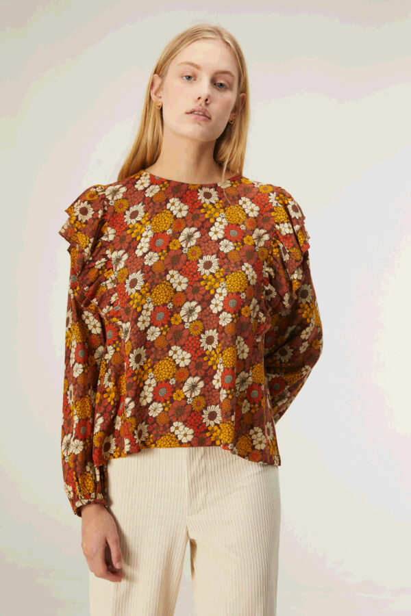 Model wears flower print blouse with ruffles