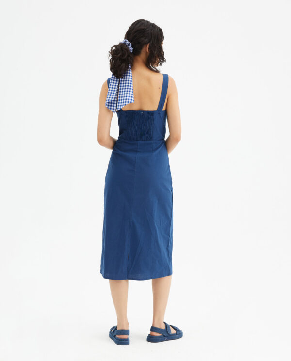 Back photo model wears blue dress with wide straps