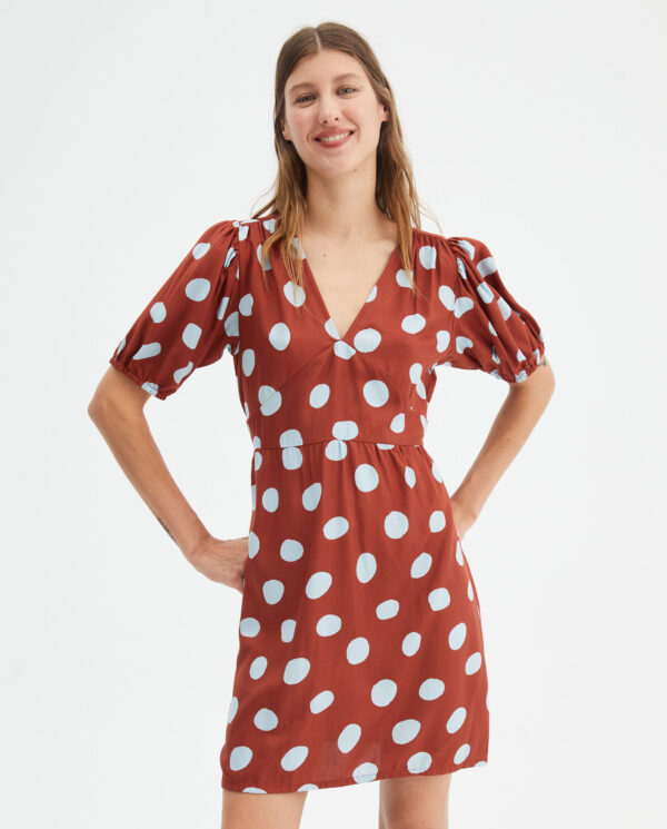 Model wears brown polka dot print dress
