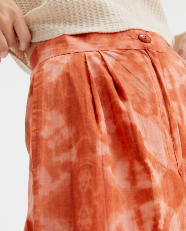 Close up photo model wears peach cotton poplin trousers